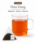Té negro Dian Hong en bolsa piramidal junto a una taza de infusión